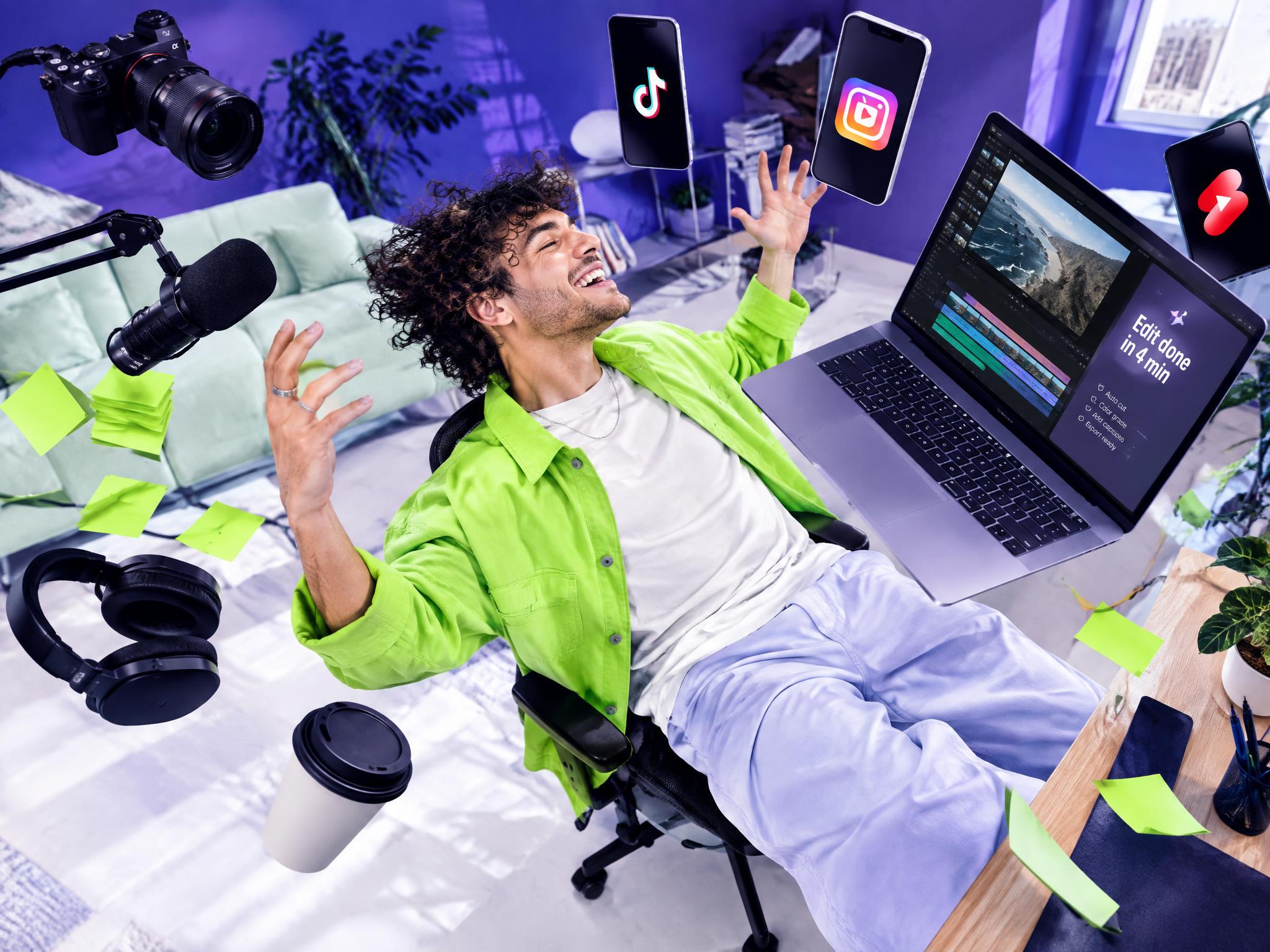 Creator celebrating at his desk surrounded by floating phones, camera and laptop