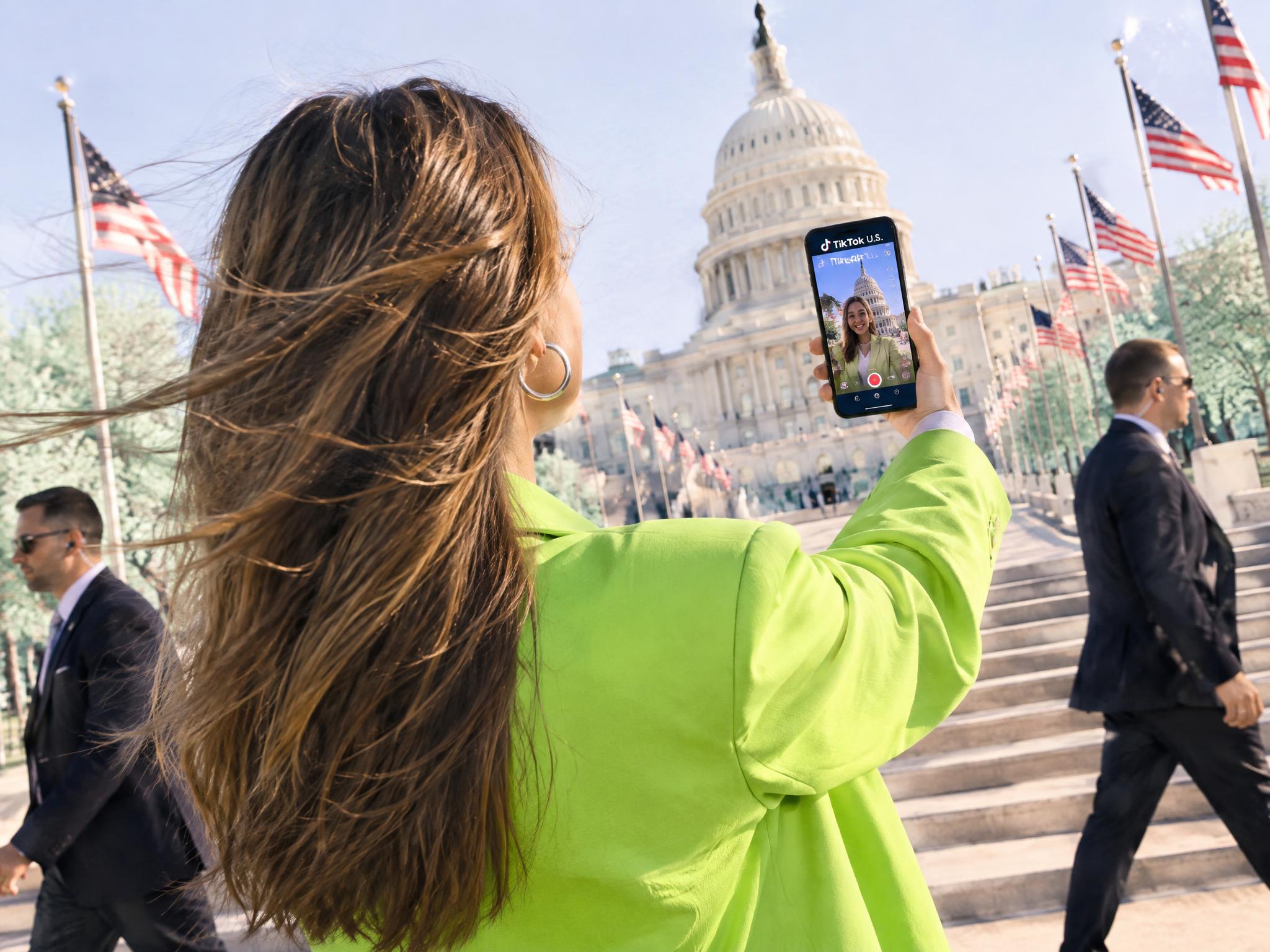 Woman filming a TikTok selfie video in front of the U.S. Capitol